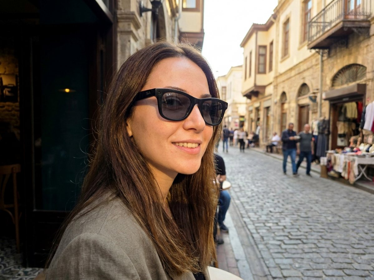 Güneşte koyulaşmış fotokromik camlı Ray-Ban Meta akıllı gözlük takan kadın