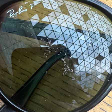 Soyulmuş, güneş yanığı gibi bozulmuş gerçek bir Ray-Ban Polarized güneş gözlüğü camı örneği