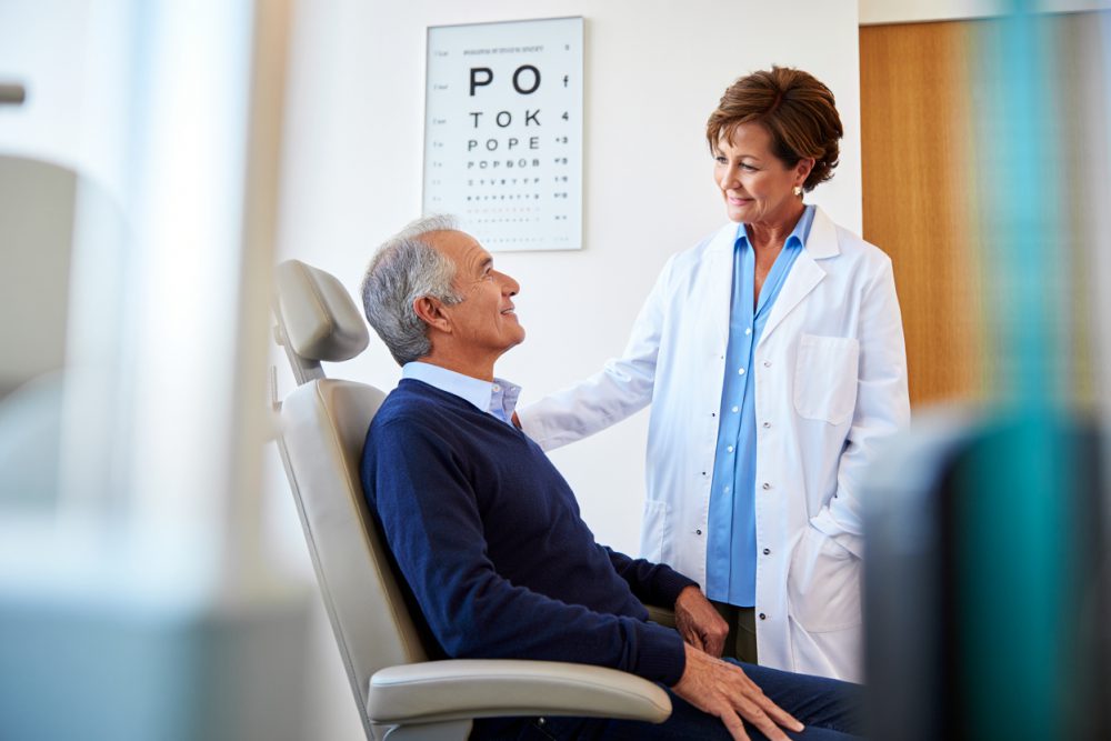 Göz muayenesinde hastayla konuşan uzman optometrist